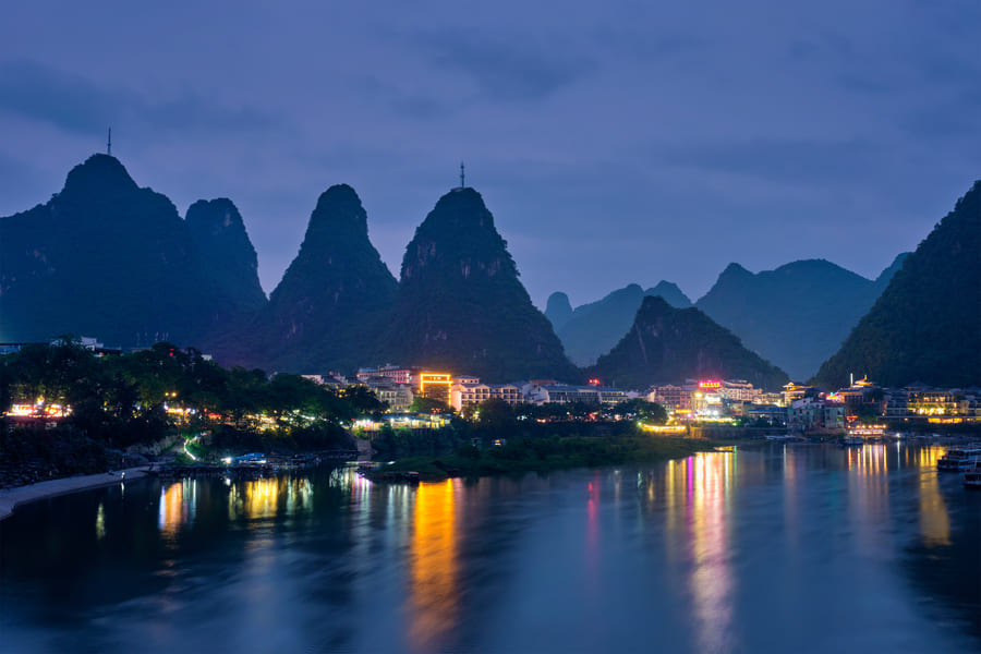 paisaje con cuerpo de agua que refleja las luces de yangshuo, china de noche